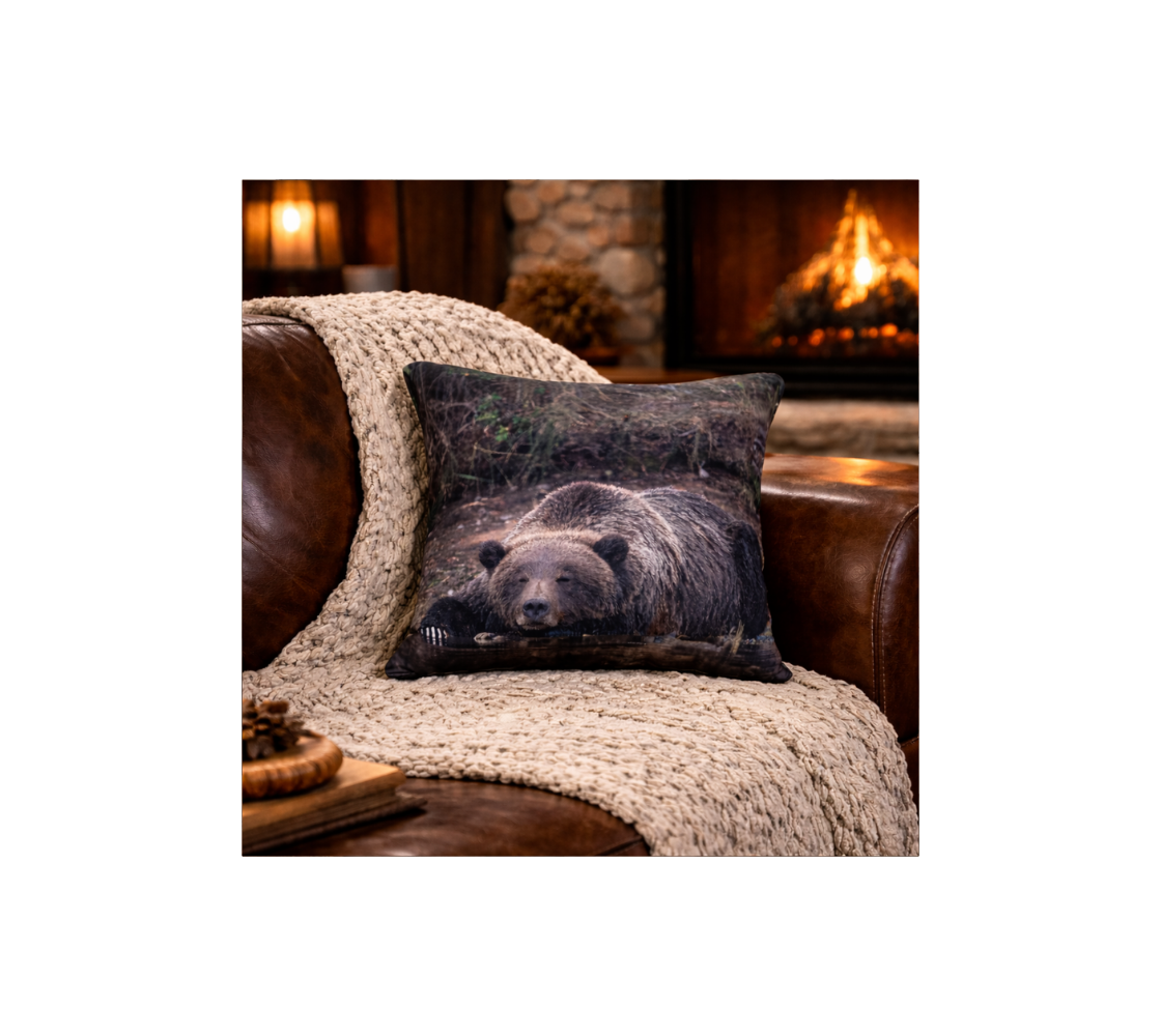 Decorative cushion cover with a grizzly bear design on a cozy sofa in a warm, inviting room.