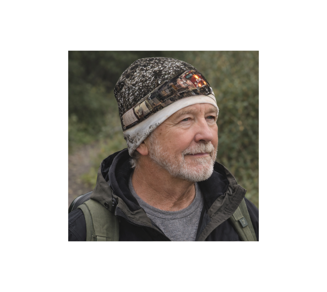 A man standing in nature wearing a bamboo-lined beanie with an image of a train at Morant's Curve design with gray and white background.