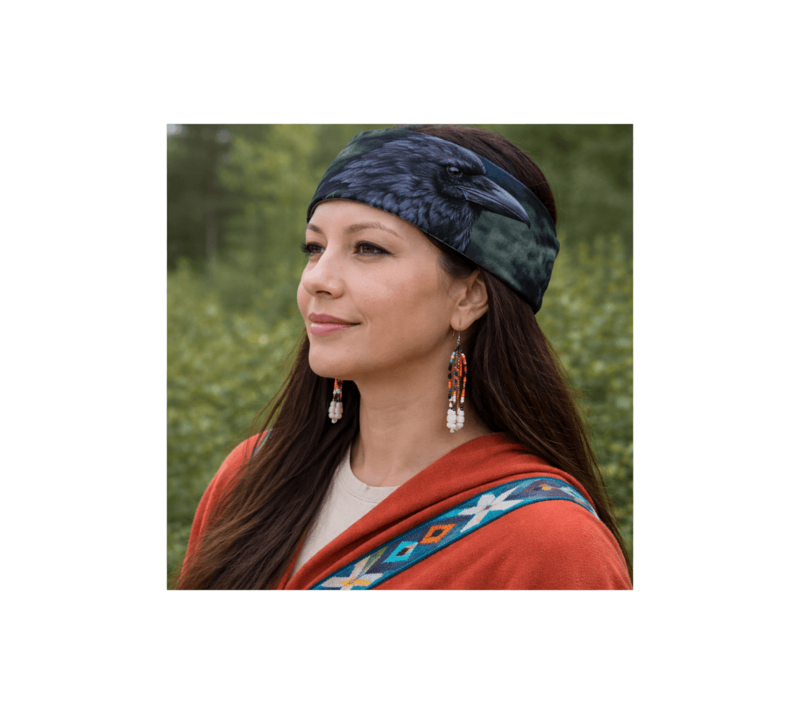 A woman wearing a raven head and neck buff from our real wildlife photography as a head band in a forest.
