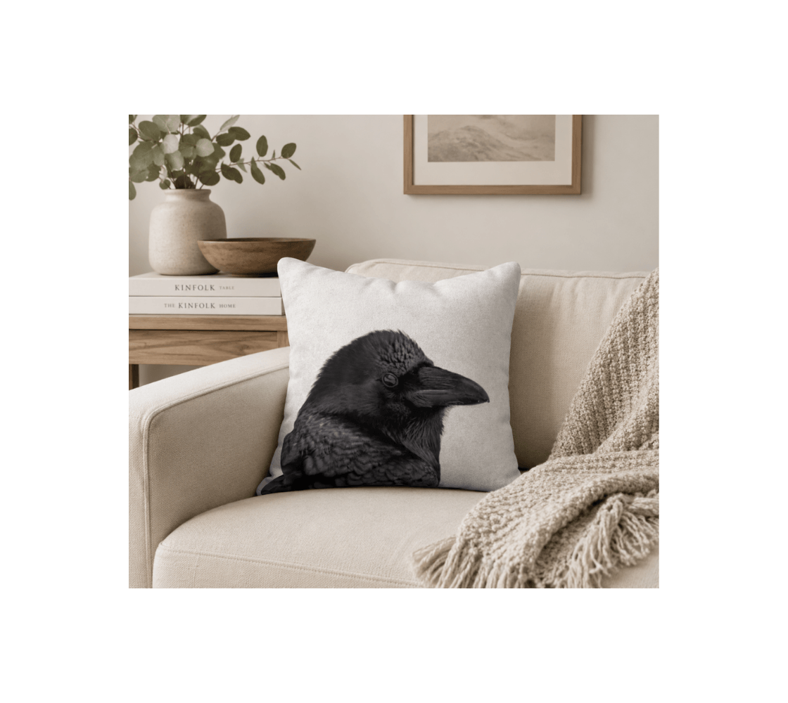 A raven throw pillow cover from our real wildlife photography in a beige chair.