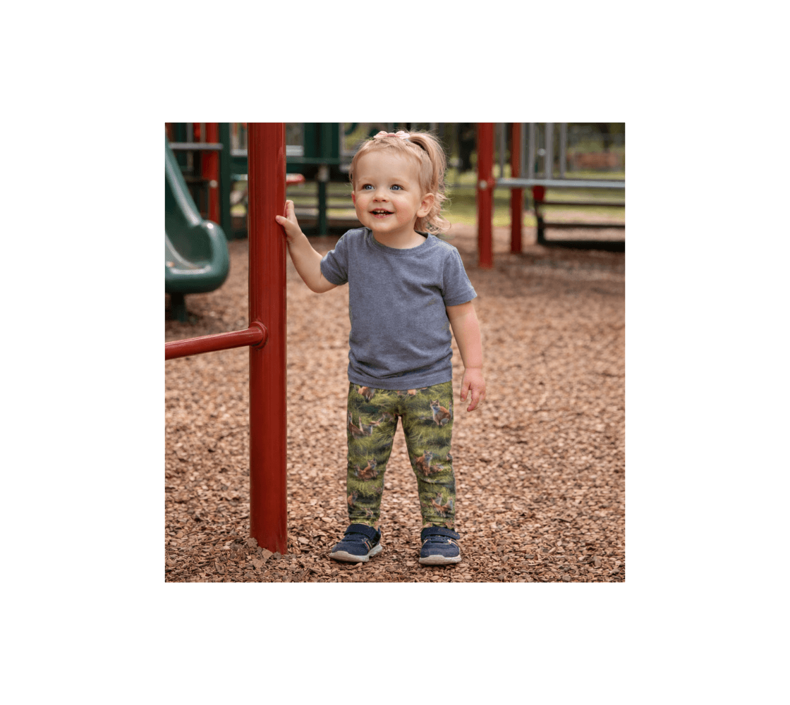 A young girl at the play ground wearing a pair of red fox kits baby leggings from our real wildlife photography. 