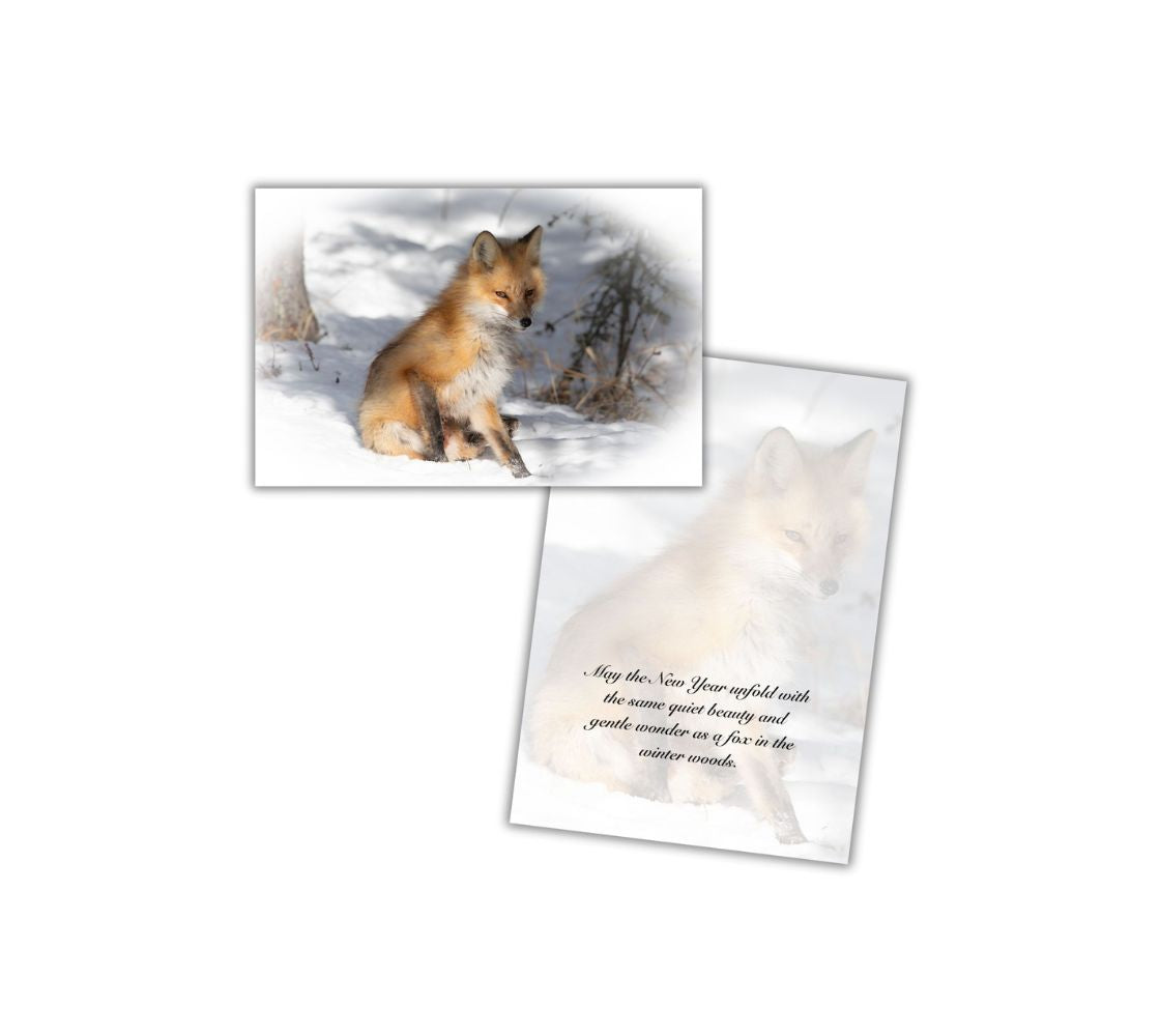 A Christmas card of a red fox sitting in the snow among the shadows of the forest and an opened card with a repeated faint image of the front image with text.