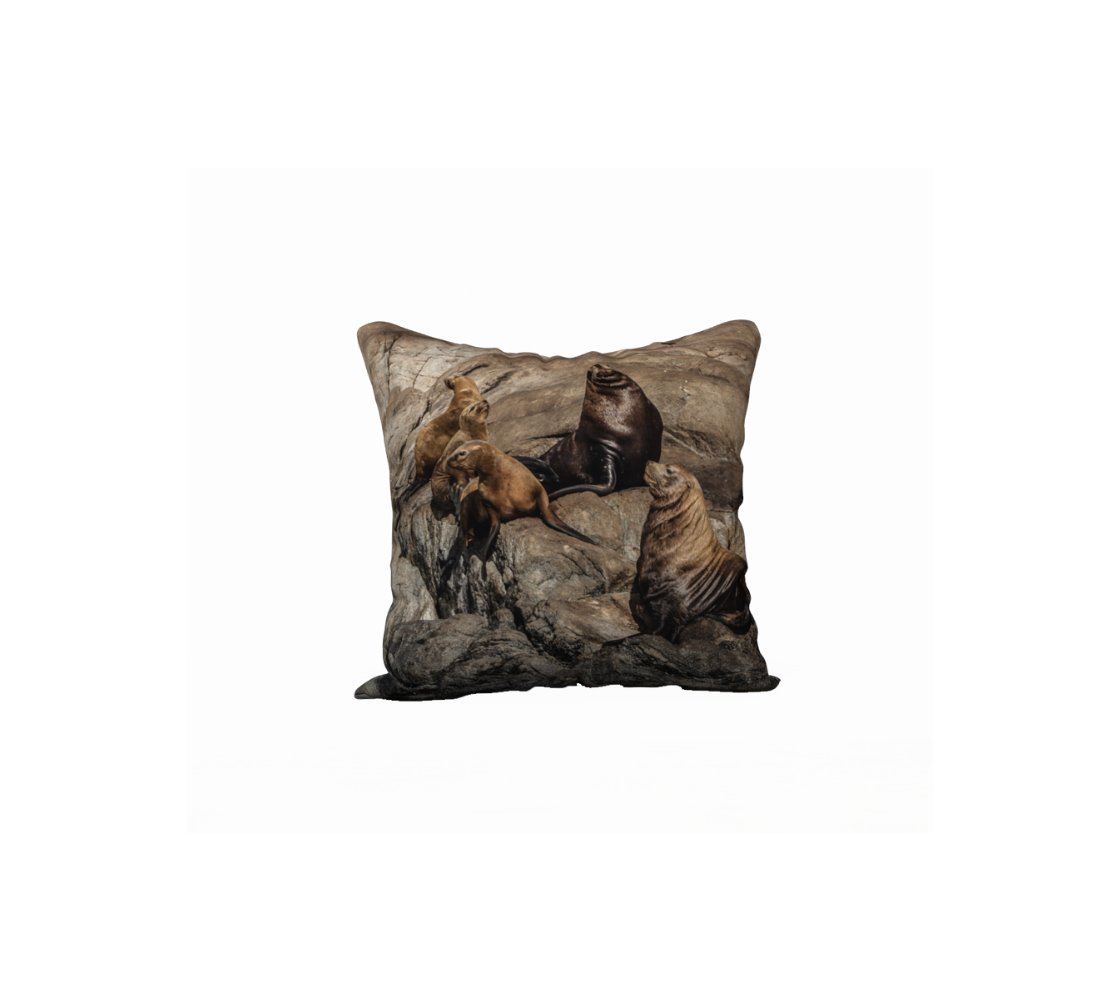 A throw pillow cover featuring an image of a sea lions on a rock design with a brown background. 