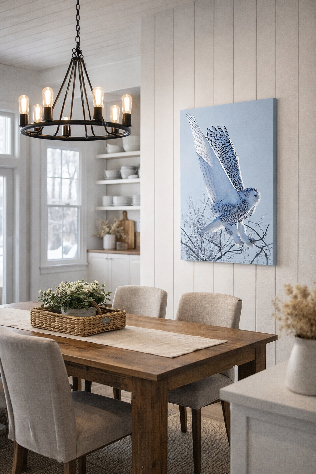 Dining room with wooden table, chairs, and a canvas print of snowy owl on the wall.