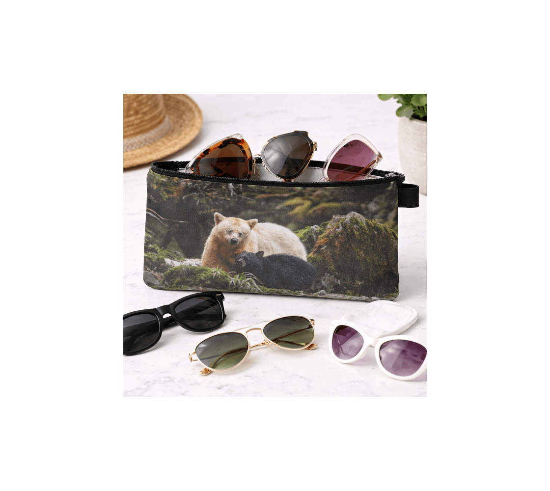 A zippered pouch with a spirit bear and black cub design from our wildlife photography with sunglasses inside it.