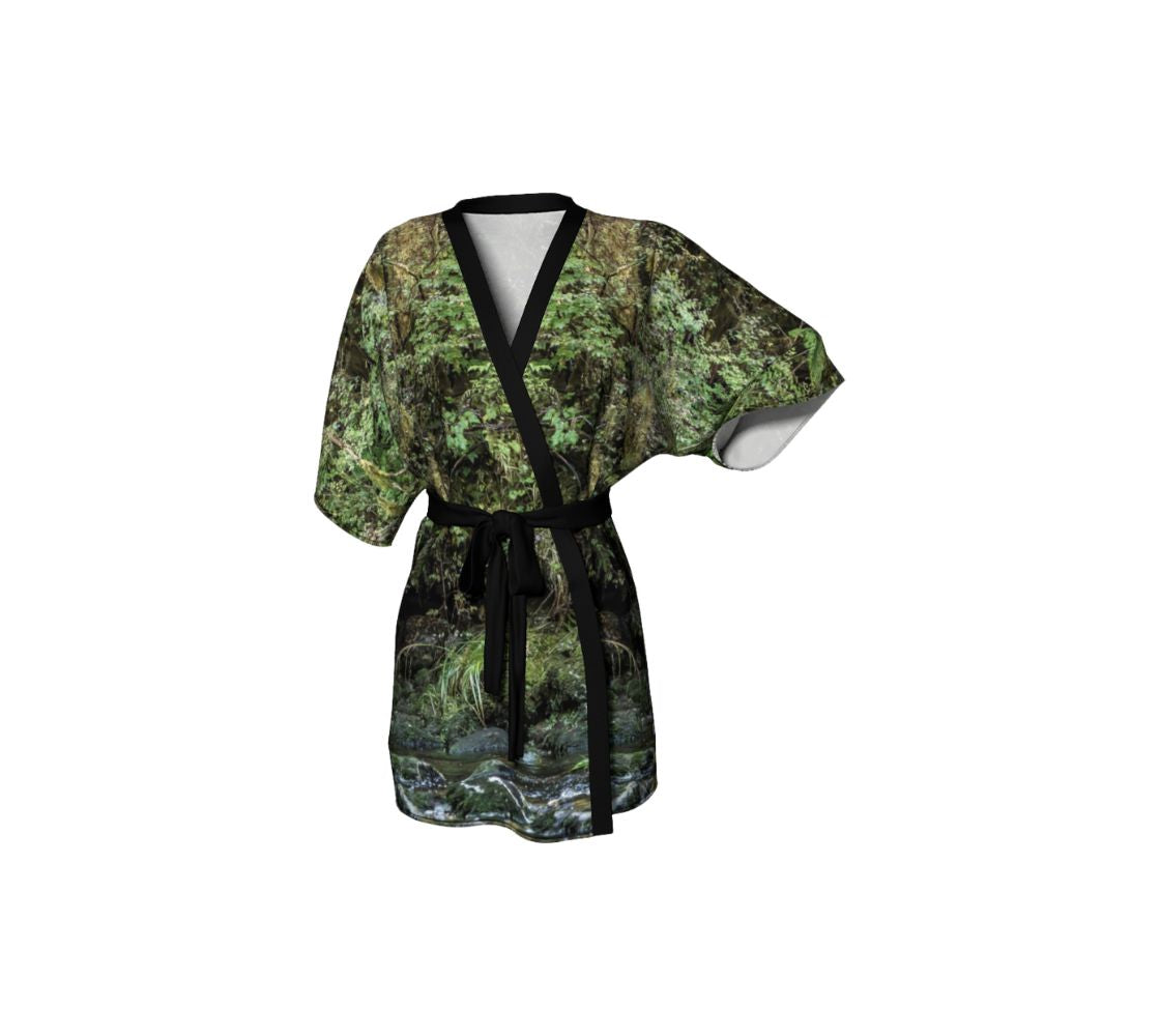 A front view of a kimono coverup featuring a spirit bear design with a green background.