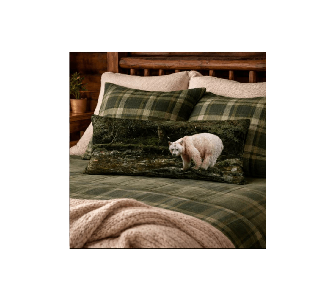 A rustic bedroom with a spirit bear decorative long throw pillow from our wildlife photography on a log bed.