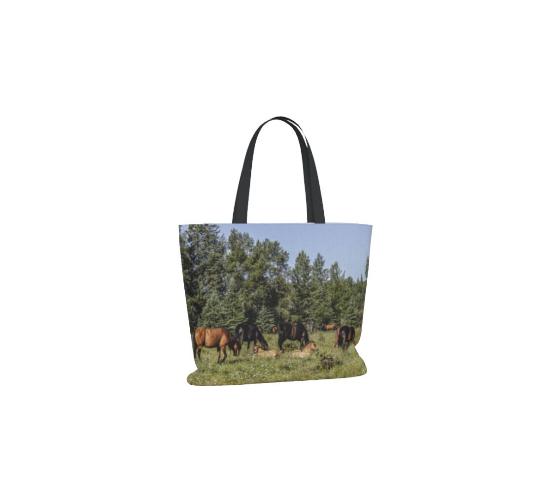 A large reusable large tote bag with an image of a herd of wild horses design with a blue and green background.