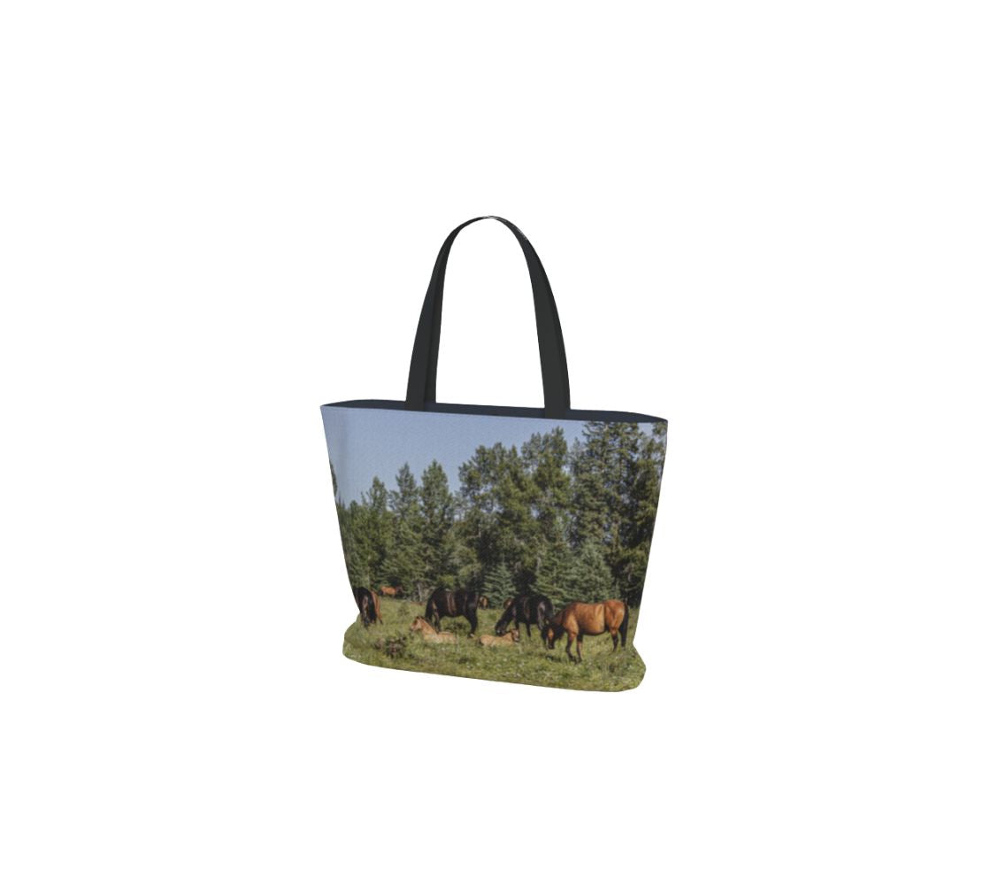 Tote bag with a design of wild horses in a field on a white background