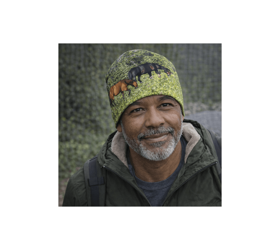 A man wearing a band of wild horses bamboo-lined beanie from our real wildlife photography with pine trees in the background.