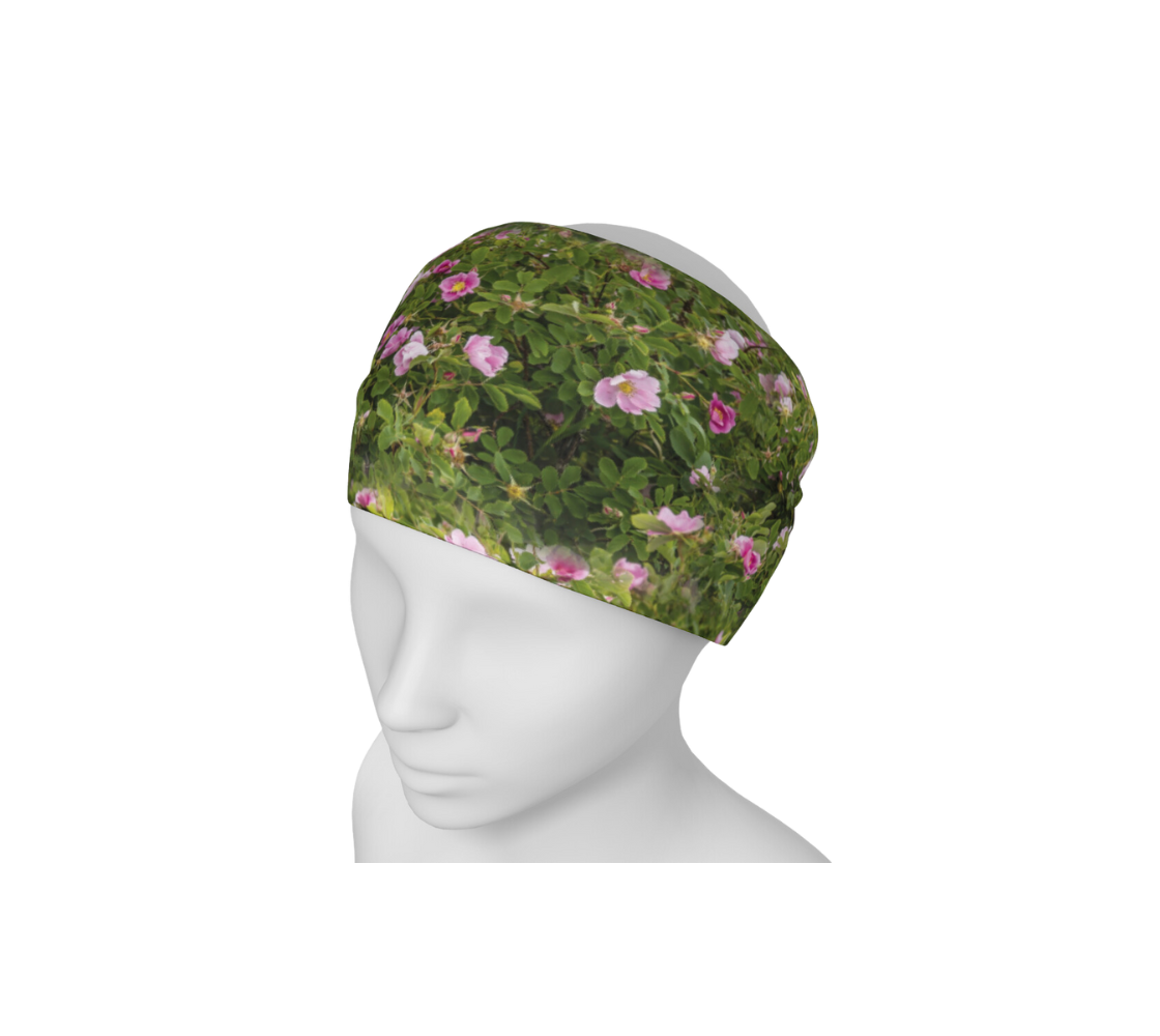 A mannequin head wearing a head and neck buff with an image of a wild rose design with a green background.