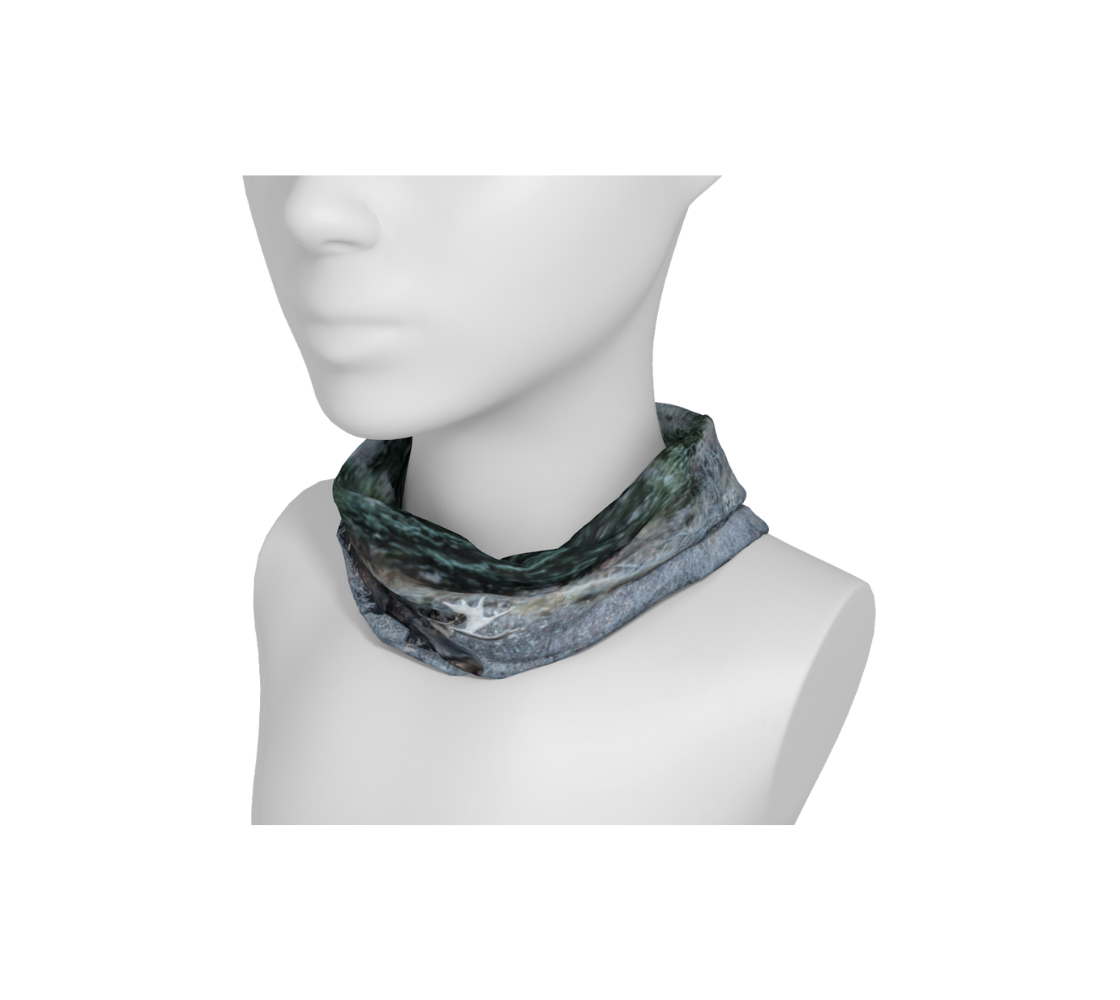 This is a image of a photo of a bull moose on a head and neck buff, worn as a neckband on a mannequin. The fabric print shows a big dark brown bull moose standing in the frosty grey willows surrounded by evergreen trees. He is covered with a blanket of white frost on his back, shoulders and head. 