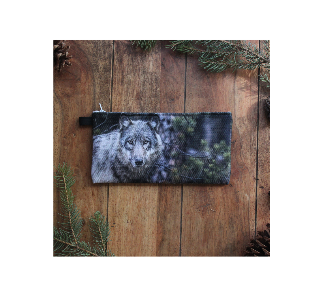 Durable double sided 9” x 4” canvas zippered pouch featuring real images of grey wolf in rocky Mountains.