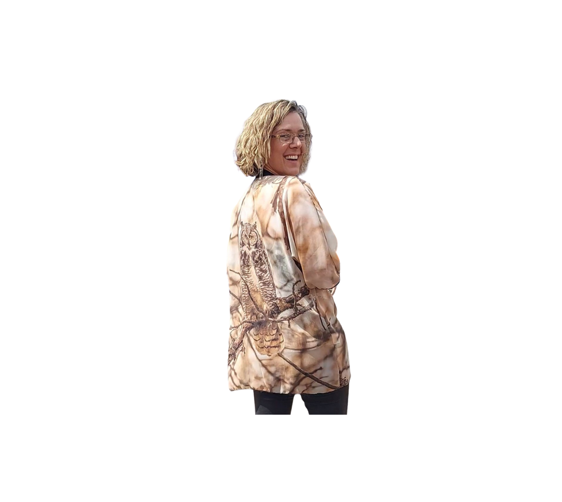 This is a backview of a lady wearing a semi-sheer poly chiffon kimono robe featuring a photo of an owl. The background is of orange, brown and white blurred tree branches, with a great horned owl on a tree branch. Kimono has black lightweight trim.