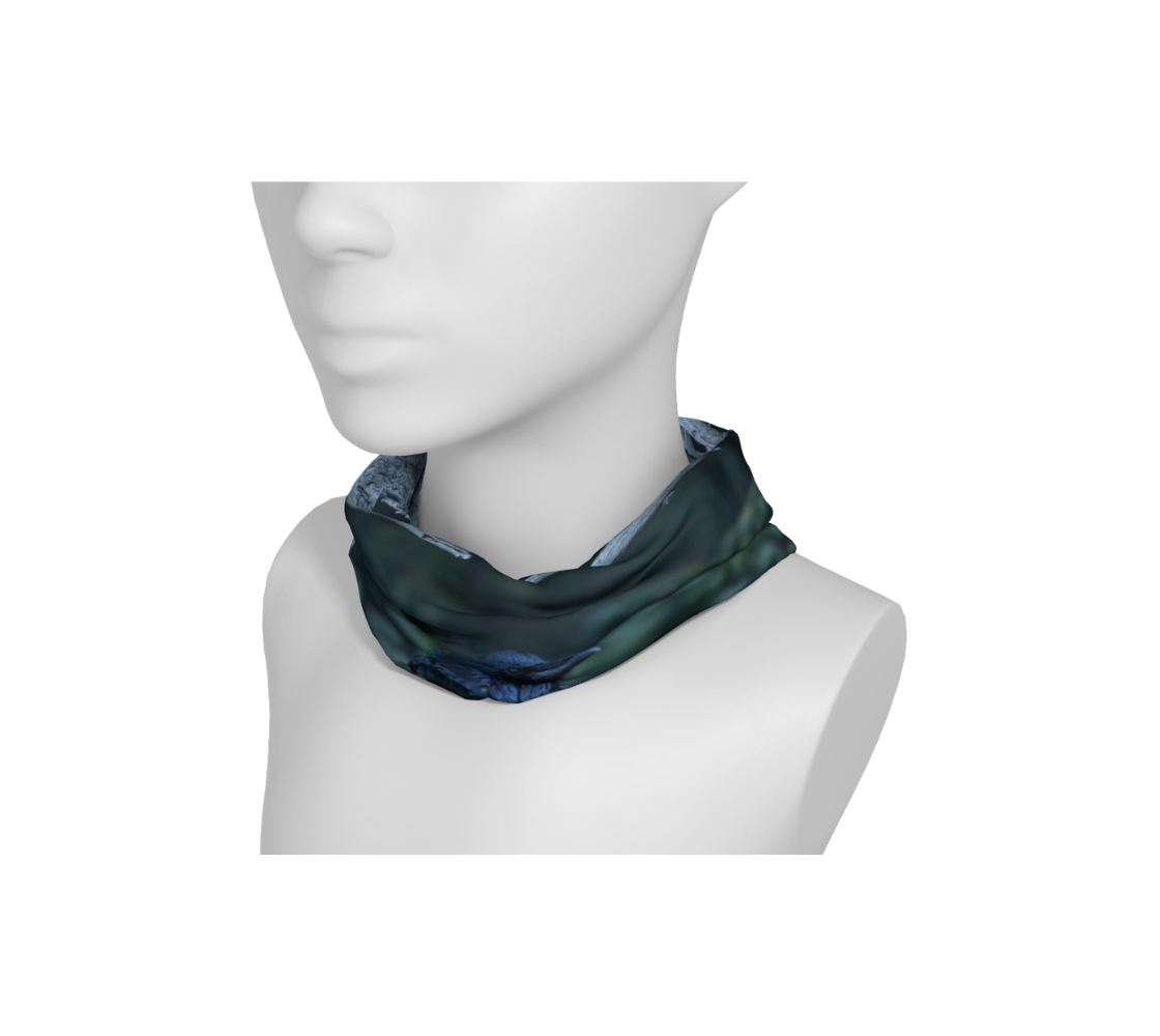 A mannequin head with a head and neck buff wrapped around the neck with an image of a raven design with a mottled green background.