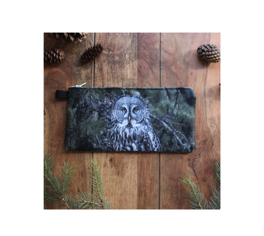 Durable double sided 9” x 4” canvas zippered pouch featuring real images of great grey owl in the spruce a tree.