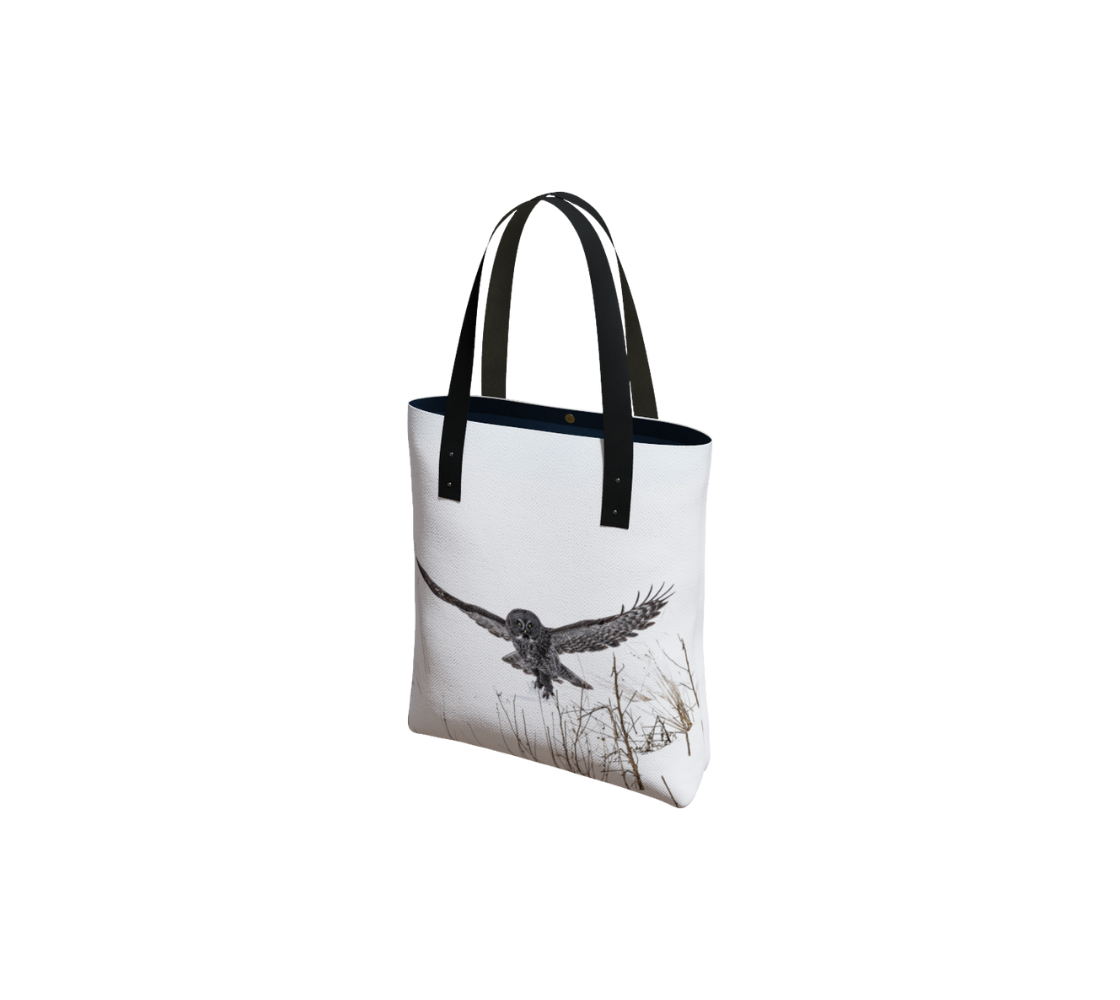 Durable canvas handbag with 1” vegan leather straps and magnetic closure with inside pockets. Features double sided real images of great grey owl in winter. Measures 16” x 13” x 3”.
